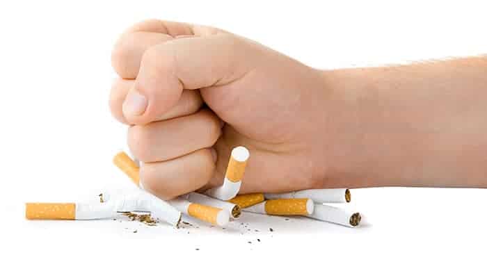 Hand crushing cigarettes on a white background.