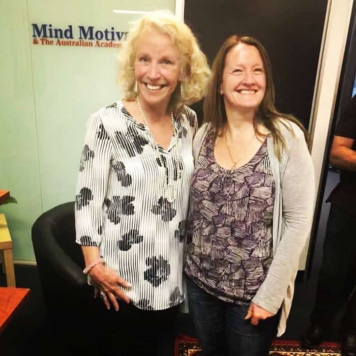 Two women smiling together at a hypnotherapy clinic.