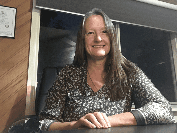Hypnotherapist seated at a desk during an online session