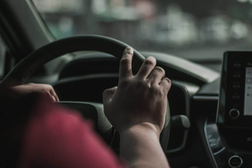 Person gripping a steering wheel during a stressful driving moment.
