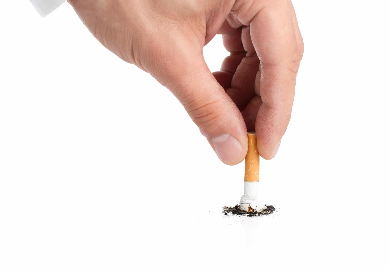Hand crushing a cigarette stub on a white surface.